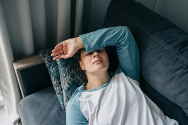 a-middle-aged-brunette-lies-on-the-sofa-with-a-hea-2026-01-11-08-57-08-utc